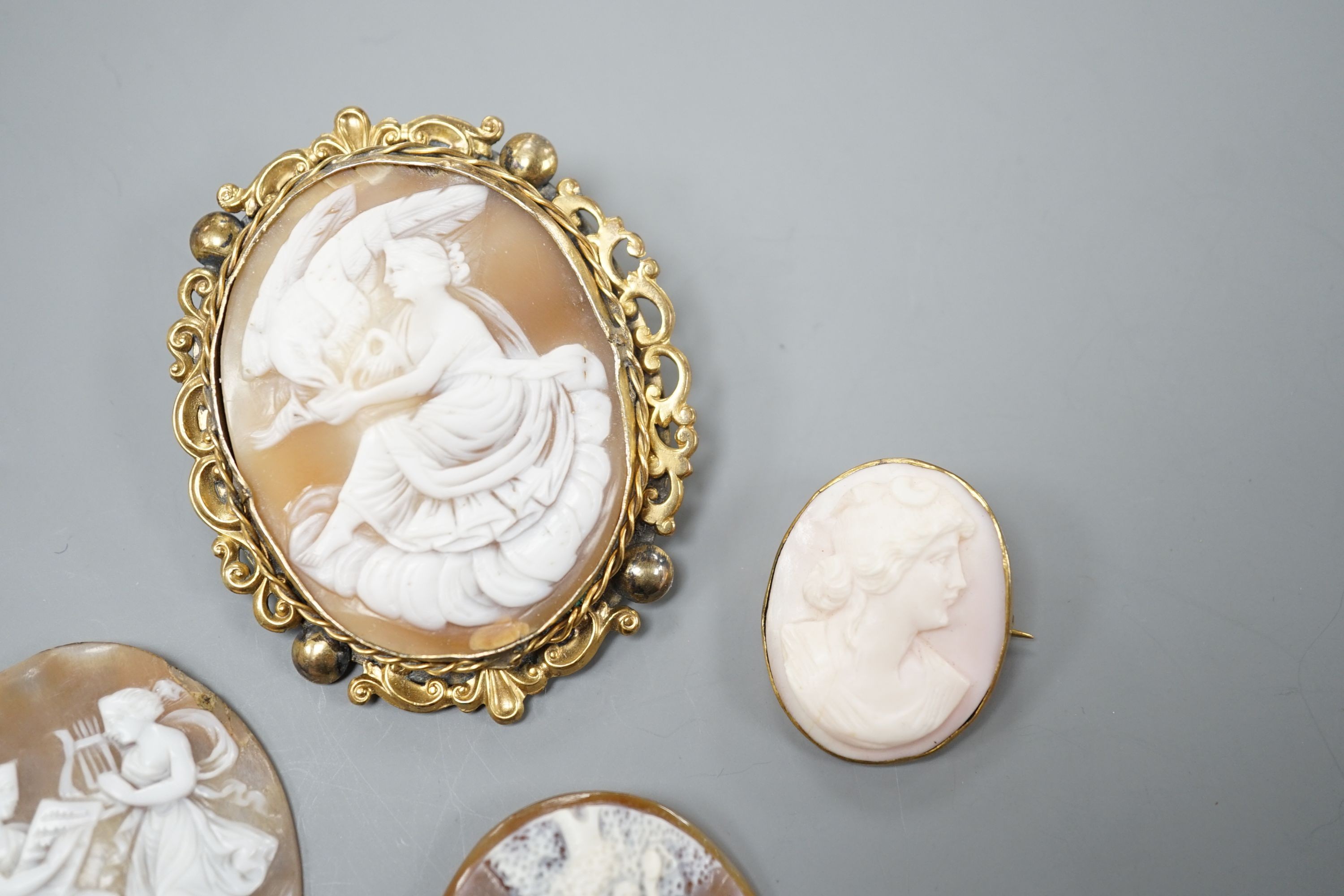Two gilt metal mounted carved oval cameo shell cameos, largest 63mm and two similar unmounted cameos.